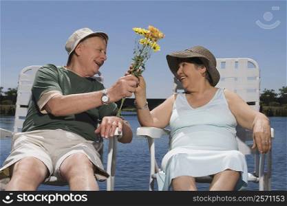 Senior man giving a bunch of flowers to a senior woman