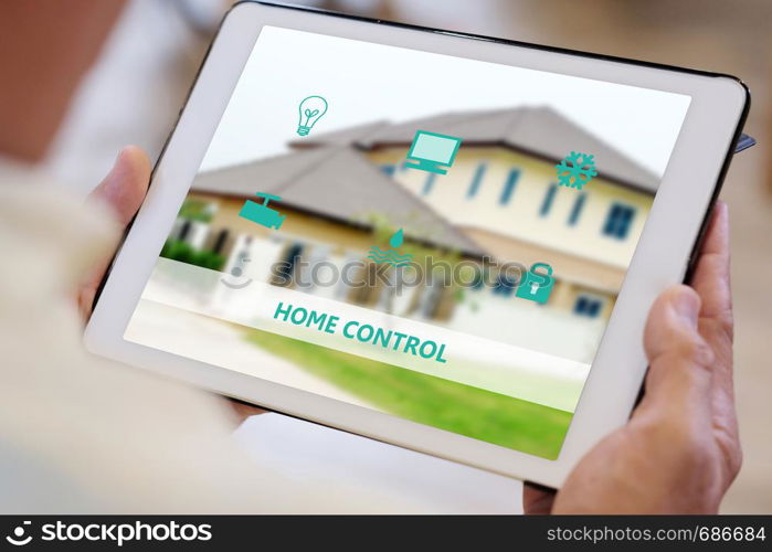 Senior man hand using digital tablet with smart home control icon on screen while sitting on sofa at home, smart home control concept