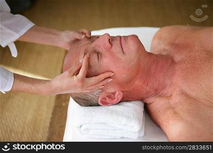 senior man having a massage in a spa center