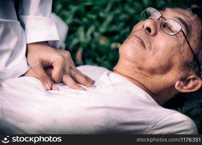 Senior man having chest pain or heart attack in the park. Old people elderly healthcare concept.