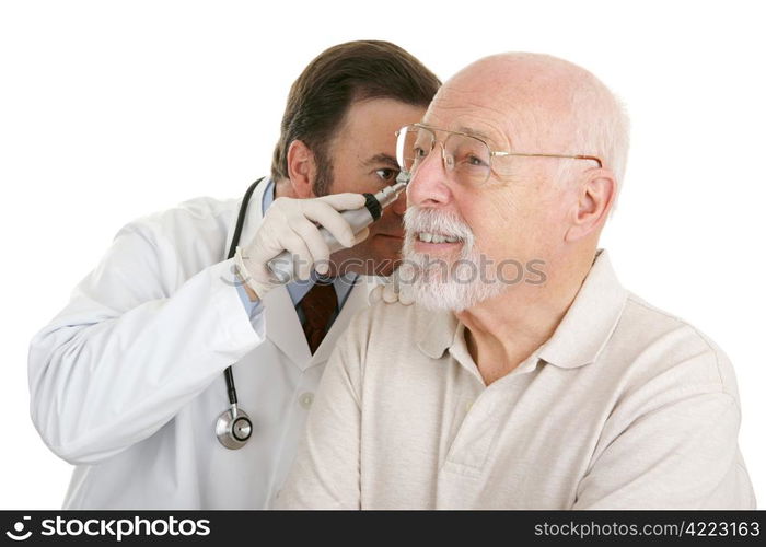 Senior man having his ears checked at the doctors office. Isolated on white.