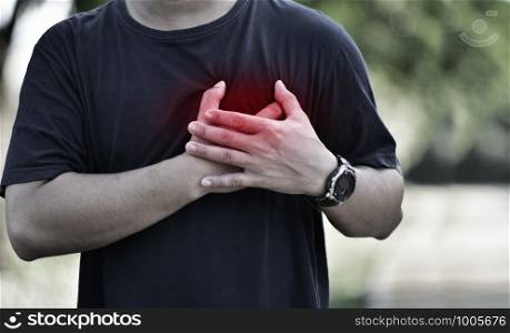Senior man heart disease holds his hand in his heart while exercising. Heart health problems