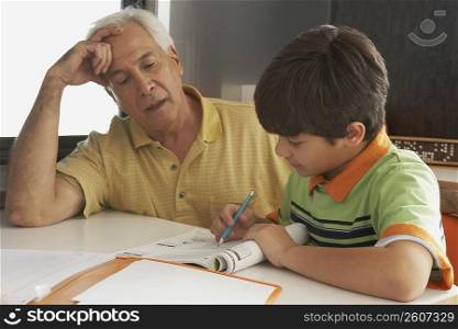 Senior man helping his grandson in his homework