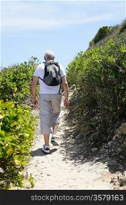 Senior man hiking by the coast