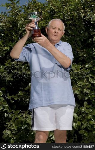 Senior man holding a trophy