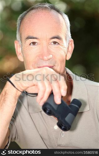 Senior man holding binoculars