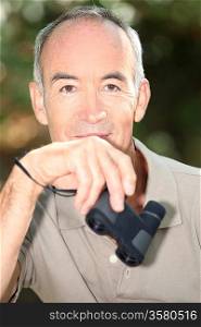 Senior man holding binoculars