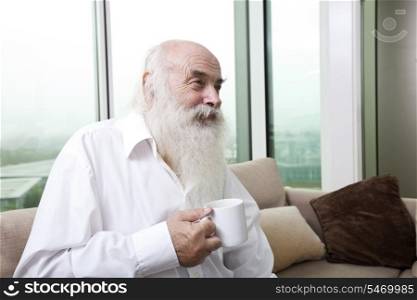 Senior man holding coffee cup at home