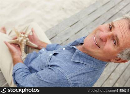 Senior man holding starfish