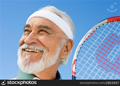 Senior man holding tennis racket