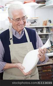Senior Man Holding Vase In Pottery Studio