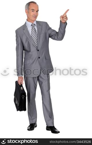 Senior man in a suit pointing skywards