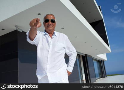 senior man in front of luxury modern home villa