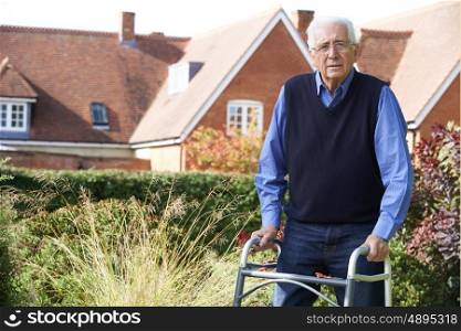 Senior Man In Garden Using Walking Frame
