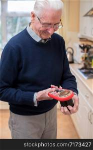 Senior Man In Kitchen Taking Lid Off Jar With Kitchen Aid