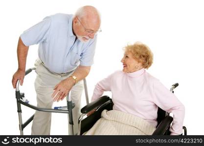 Senior man in walker flirting with a senior lady in a wheelchair. Isolated on white.