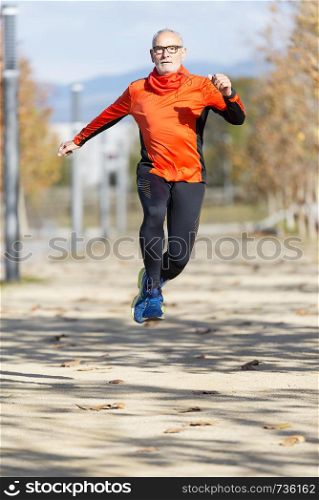 Senior man jumping in a city park ( lifestyle )