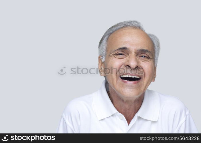 Senior man laughing over white background