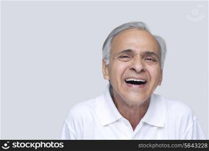 Senior man laughing over white background