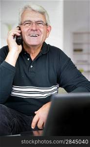 Senior man laughing whilst on the telephone