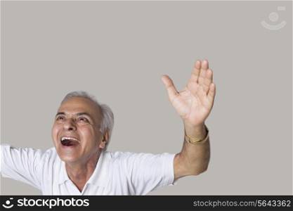 Senior man laughing with arms raised