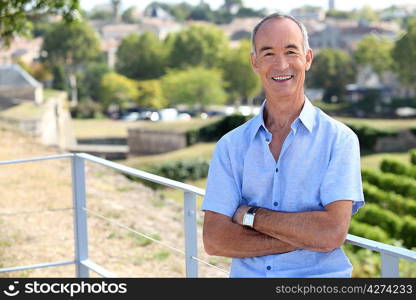 Senior man leaning against railing