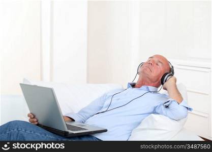 Senior man listening to music with headphones