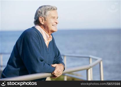 Senior Man Looking Over Railing At Sea