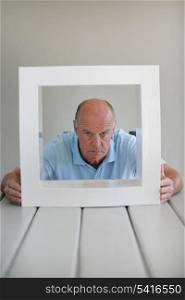Senior man looking through a frame