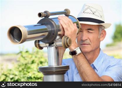 Senior man looking through a telescope