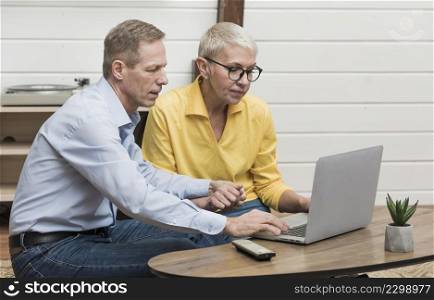 senior man looking through his laptop his wife