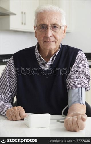 Senior Man Measuring Blood Pressure At Home