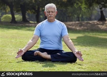 Senior man meditating in park
