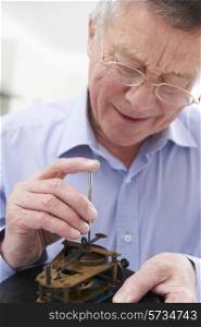 Senior Man Mending Clock Mechanism