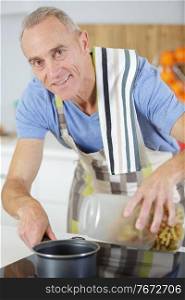 senior man mixing something in pan