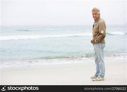 Senior Man On Holiday Standing On Winter Beach
