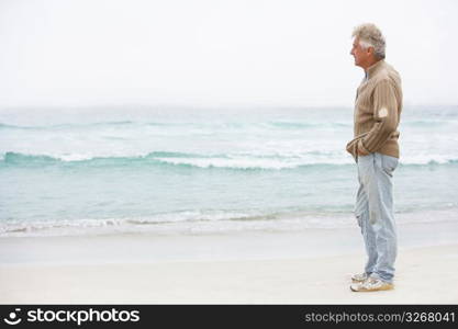 Senior Man On Holiday Standing On Winter Beach