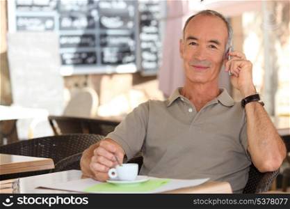 Senior man on phone drinking a coffee