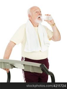 Senior man on treadmill takes a break to drink from a water bottle. Isolated on white.