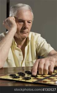 Senior man playing checkers