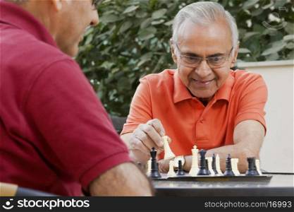 Senior man playing chess with friend