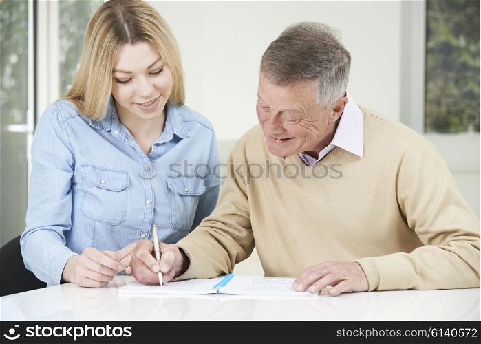 Senior Man Playing Completing Sudoku Number Puzzle With Teenage Daughter