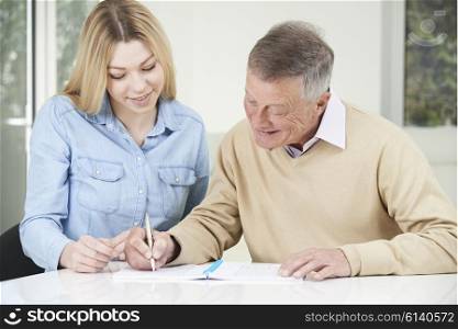 Senior Man Playing Completing Sudoku Number Puzzle With Teenage Daughter