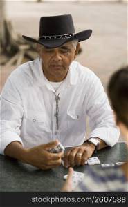 Senior man playing dominos, outdoors