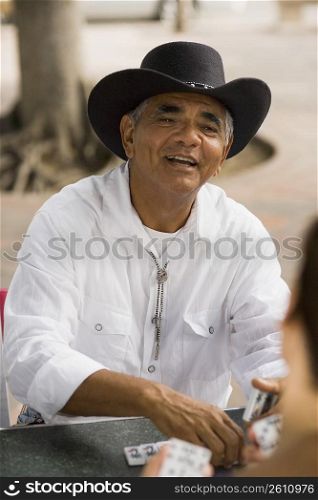 Senior man playing dominos, outdoors