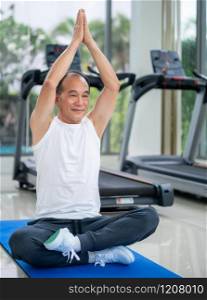 Senior man practice yoga in fitness gym. Mature healthy lifestyle.. Senior man practice yoga in fitness gym.