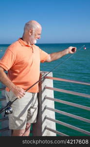 Senior man preparing to bait his fishing hook and catch some fish.