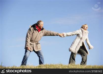 Senior Man Pulling His Wife By The Hand