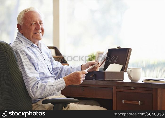 Senior Man Putting Letter Into Keepsake Box