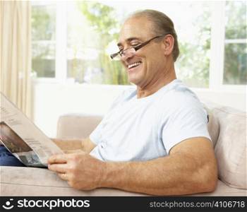 Senior Man Reading Newspaper At Home